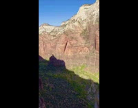Guy stands on edge of canyon cliff 
