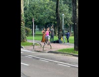 Woman in mustard dress poses on the sidewalk
