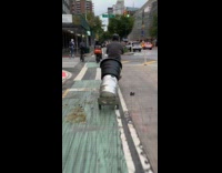 Man rides bike drags hand truck with keg