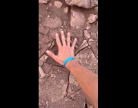 Man crushing dried up crunchy mud 