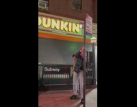 Man Holds Up Friend on Street Pole for Picture