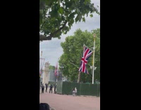 Two women tiktok dance near the English flag