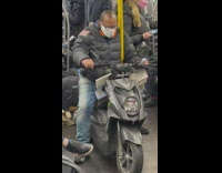 Guy sitting on scooter in the subway train