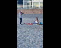 Woman beach picnic photoshoot while kid watches