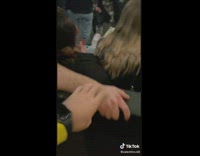 Guy puts arms on shoulders of women