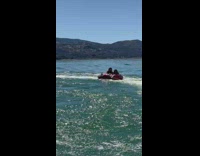 2 people on red raft with boat 