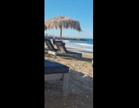 Mother takes pictures of son at the beach shore