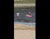 Man play guitar pink Flamingo floater beach