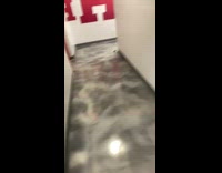 Girl chases by small mouse through hallway 