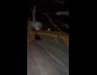 Guy sits on a sled while pulled by friend 
