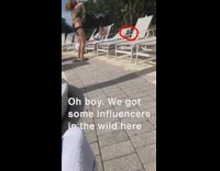 Girl dances by pool chairs