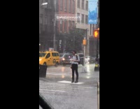 Man drenched in rain waiting at sidewalk