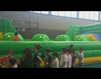 Boy jumps on green bounce house obstacle course circles and falls off