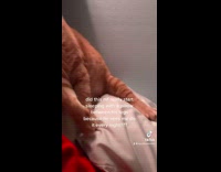 Orange cat sleeping with pillow between legs 