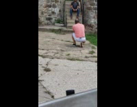 Guy sits poses stairs pink shirt 