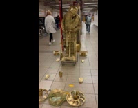 Collab WINY - Gold colored human statue in subway station