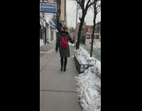 Lady uses dumbbell while walking down street 
