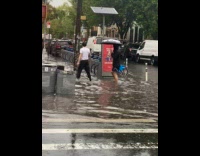 Collab WINY - People and car pass by flooded street