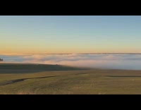 Low white clouds over street and grass