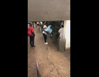Two men carry around IGOR statue light blue tuxedo and blonde in subway station