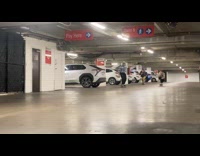 Three guys ride skateboard one falls down