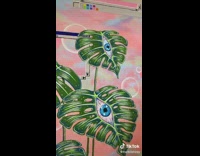 Artist paints plant leaves with eyes