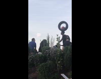 Guy balances ball inside tire on head 