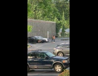 Guy black jacket stand between two cars