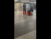 Guy playing trumpet while walking around with buckets