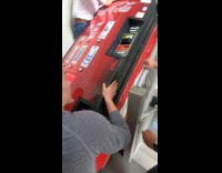 Men lifts vending machine at the stairs