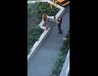Girl walks across cement planter guy camera 