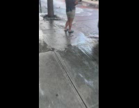 Man sit in front of open fire hydrant