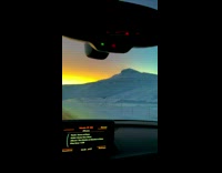 Car ride between hills with beautiful sunset