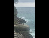 Girl white shoes kneels abandoned bunker ocean 
