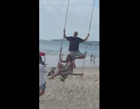 Couple pose on swing fall down beach