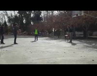 Guys jumping off chair to rebound basketball off of backboard second guy falls and chair falls over