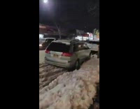 Car pulls guy on snowboard down street