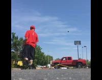 Man kicks football into basketball hoop in the back of a moving truck