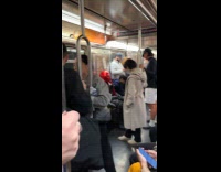 Person wears red hood helmet rides train