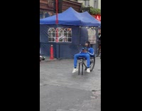 Man in blue tracksuit sits on broken bike at the street