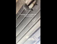 Woman checking for rust underneath car