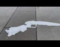 Snow on the sidewalk formed like a rifle gun