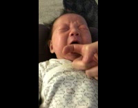 Mother put finger in mouth of crying baby