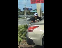Man counts money on the back of the car in front of a camera