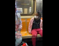 Girl on subway stares down guy wearing pastel outfit 
