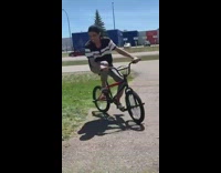 Guy falls off bike backwards in grass