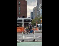 Man rides the bike with long stick