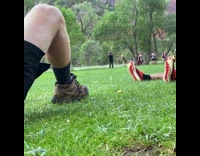 Woman black top animal print skirt poses at the park
