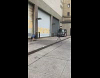 Man blue shirt does yoga in front of building garage 