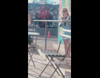 Girl poses with dandelion in front of mural 